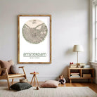The image is a framed print of a map of Amsterdam, with the city's name and location printed below the map.