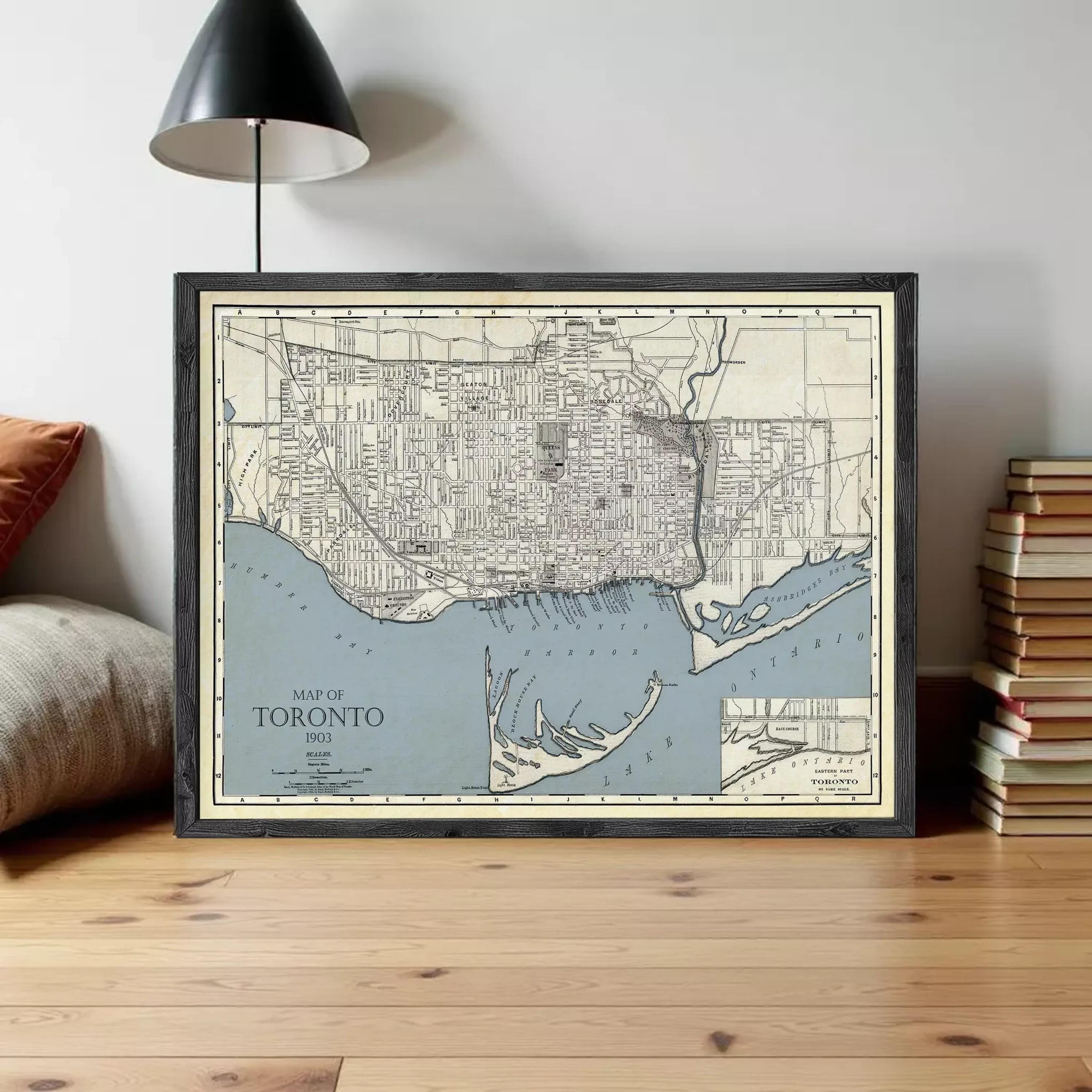 A framed vintage map of Toronto, Canada, depicting the city's streets and surrounding areas.