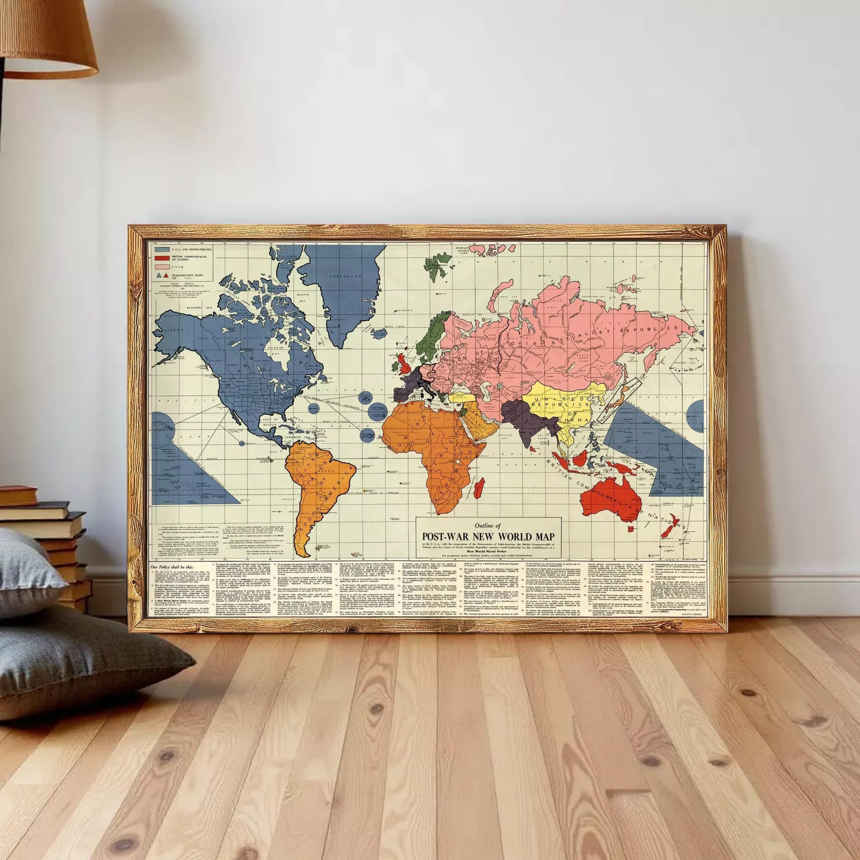 A framed vintage world map depicting the post-war world map, with various colored regions representing different countries and territories.