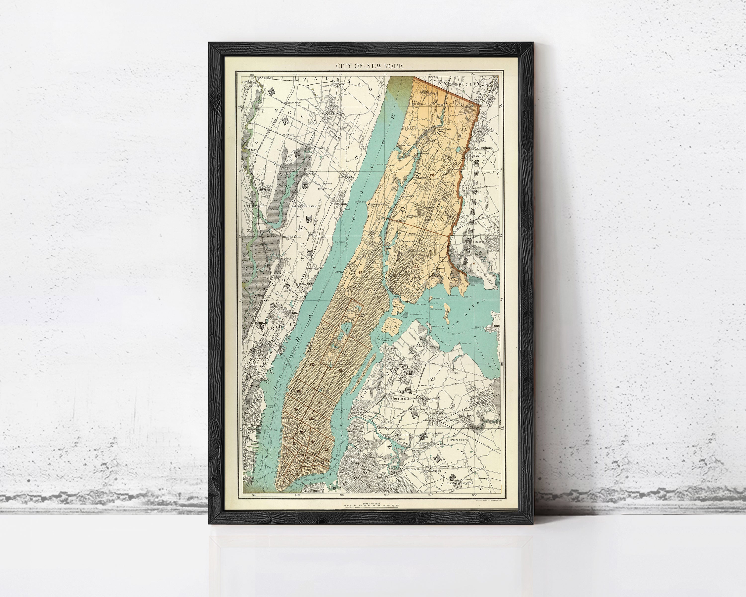 The image is a framed vintage map of New York City, depicting the city's streets and surrounding areas.