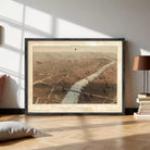 The image is a framed aerial view of a city, depicting a river or canal running through the center of the city.