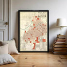 A framed map of Wichita Falls, Texas, displayed on a wall in a room with a stack of books and a lamp.