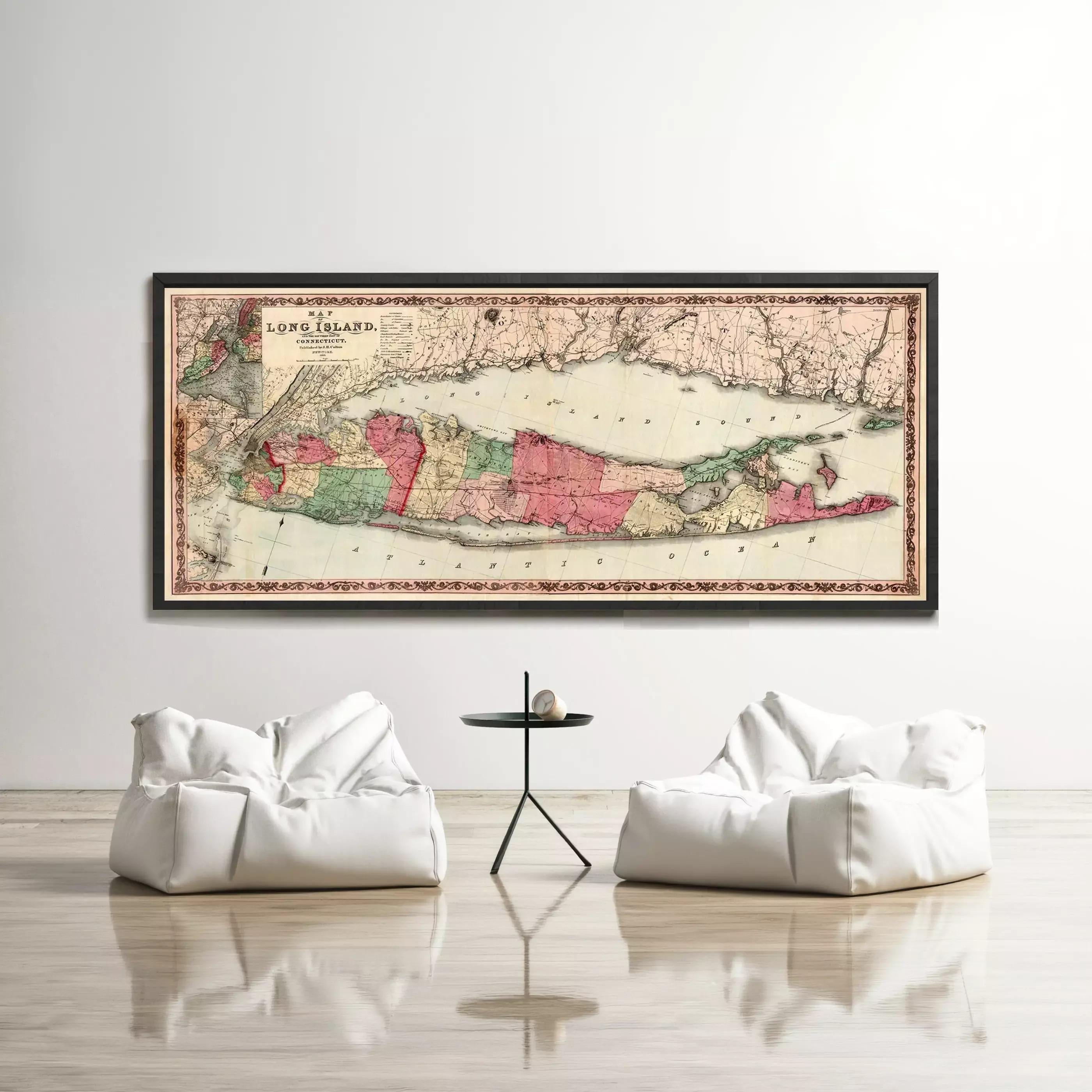 a large framed map of Long Island, New York, hanging on a wall above two white bean bag chairs in a minimalist living room setting.