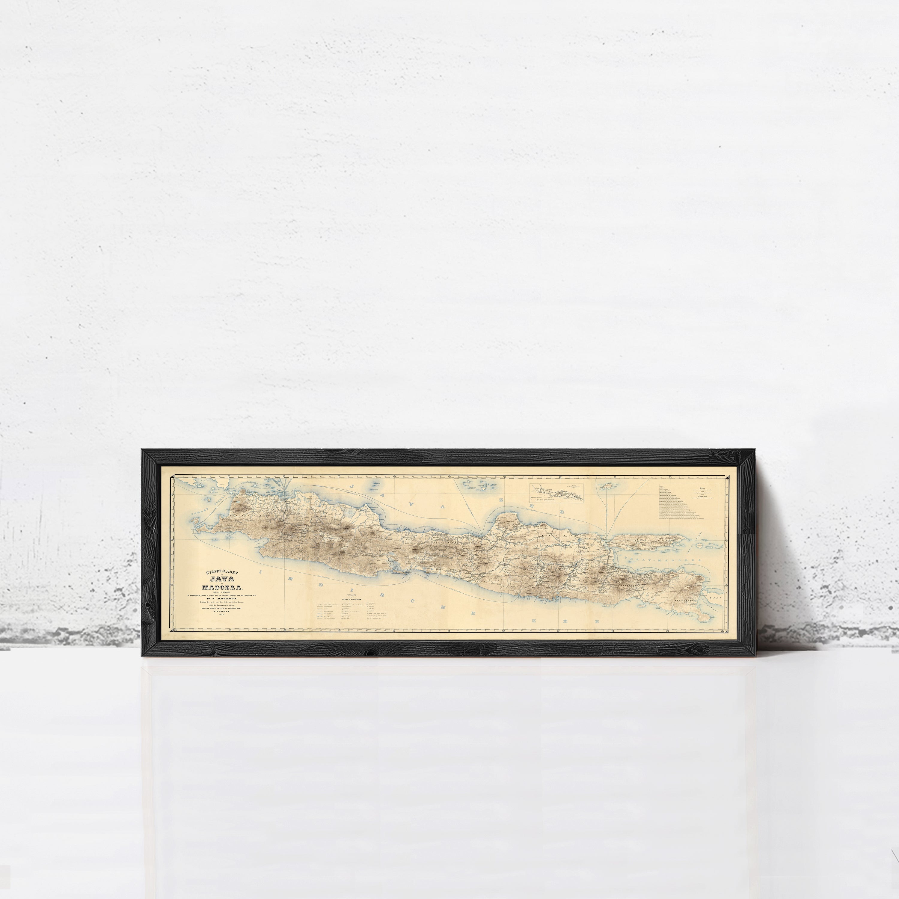 A framed map of Madagascar, a country in the South Pacific, is displayed against a white wall.