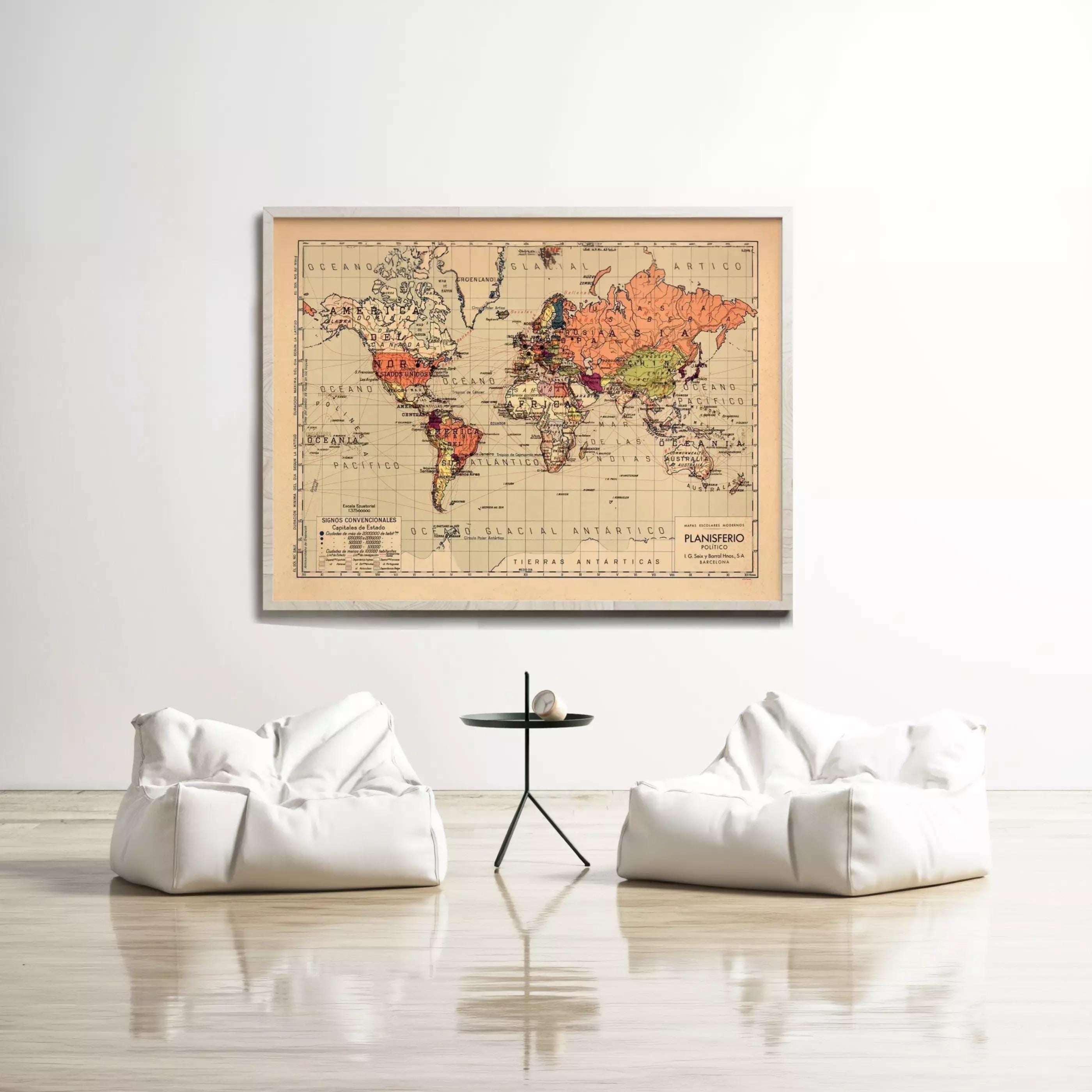 a large world map hanging on a white wall, with two white bean bag chairs positioned in front of it.