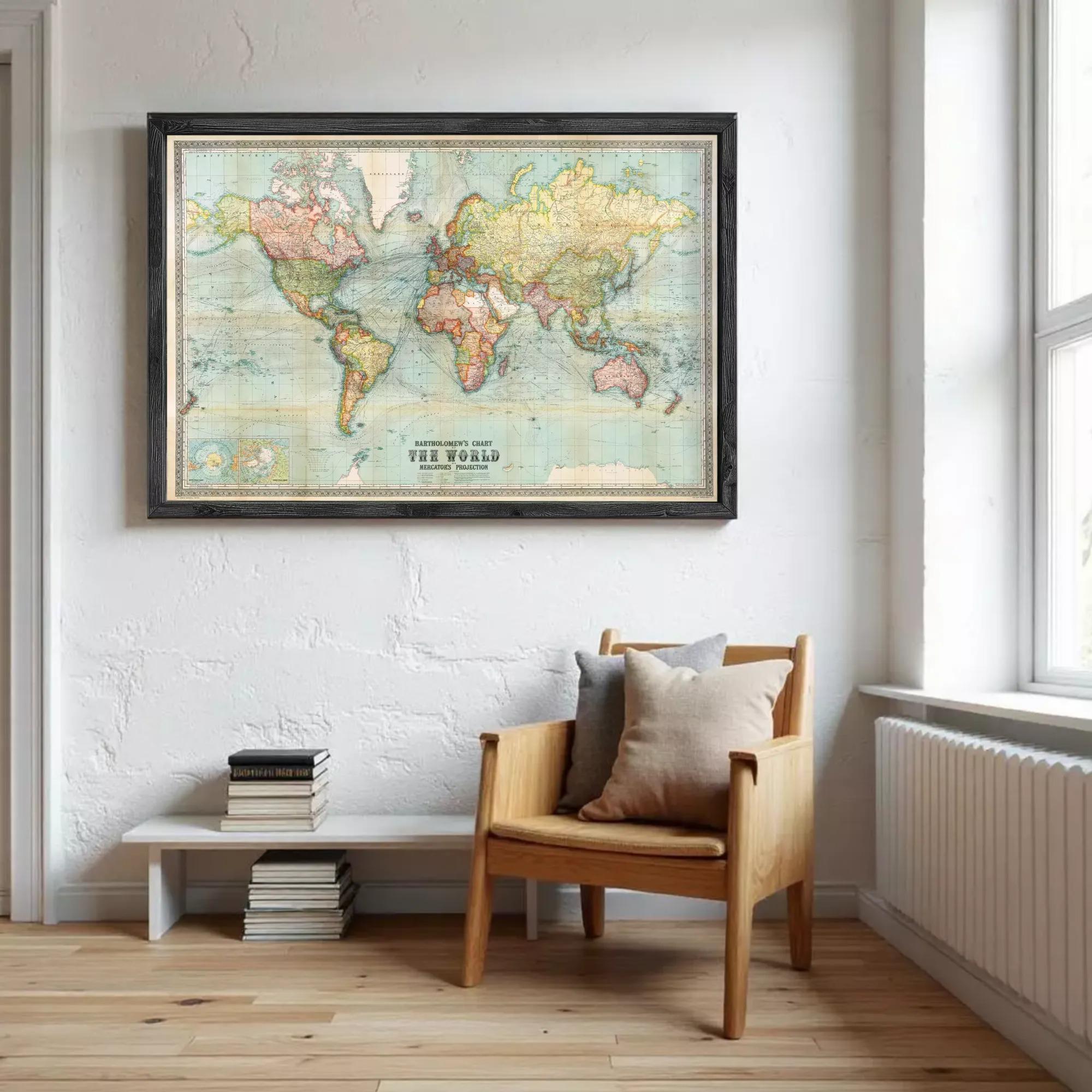 a large world map hanging on a white wall, with a wooden chair and a stack of books placed in front of it.