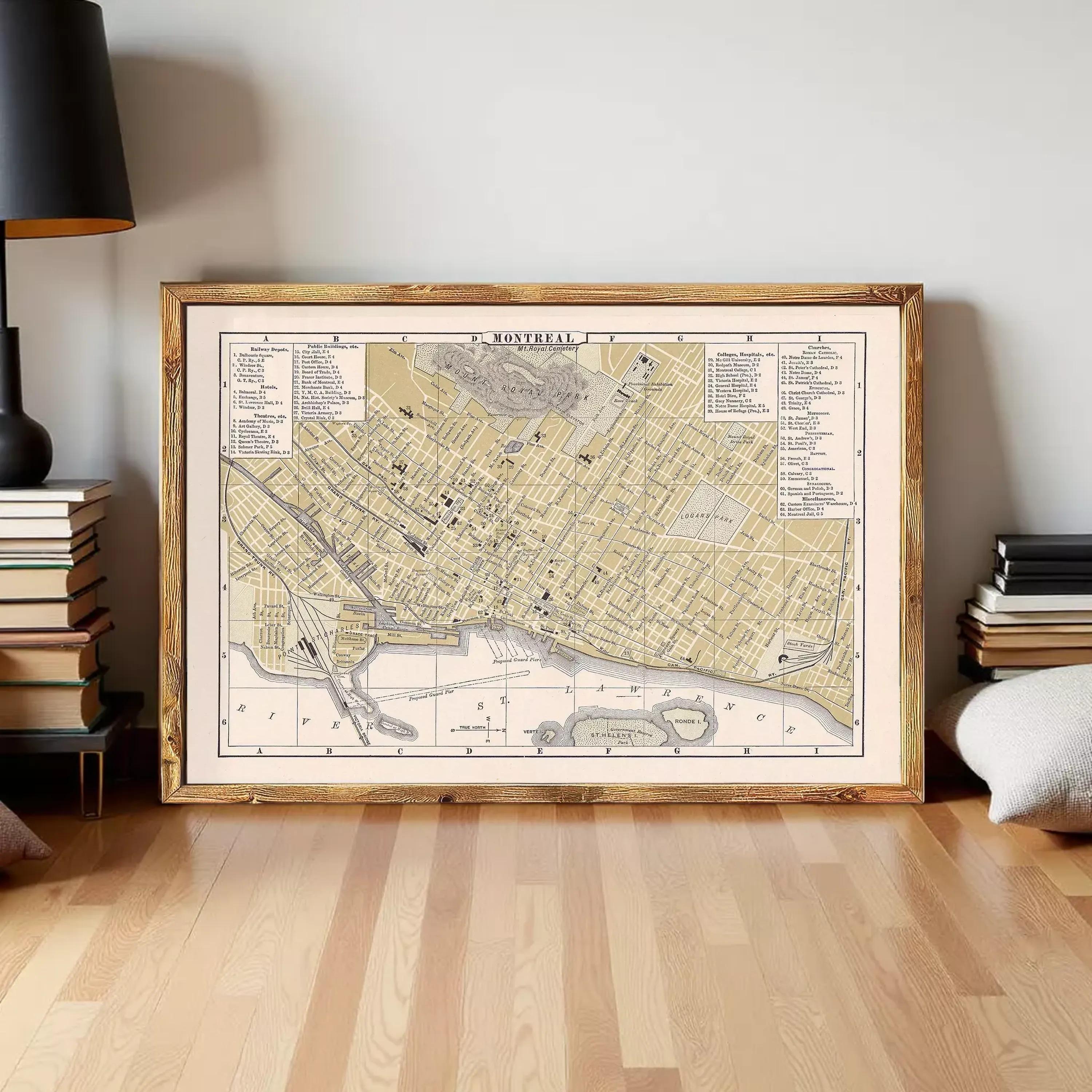 The image is a framed vintage map of a city, likely from the 19th century, displayed on a white wall.