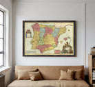 The image is a framed vintage map of Spain, featuring colorful regions and a coat of arms.