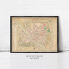 The image is a framed vintage map of a city, likely from the 19th century, displayed on a wall.