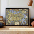 The image is a large framed map of London, England, with various landmarks and streets depicted in a detailed and colorful manner.