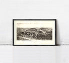 A framed black and white illustration depicting a rural landscape with buildings, trees, and a road.