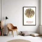 a cozy living room with a wooden chair, a lamp, and a framed map of São Paulo, Brazil, hanging on the wall.