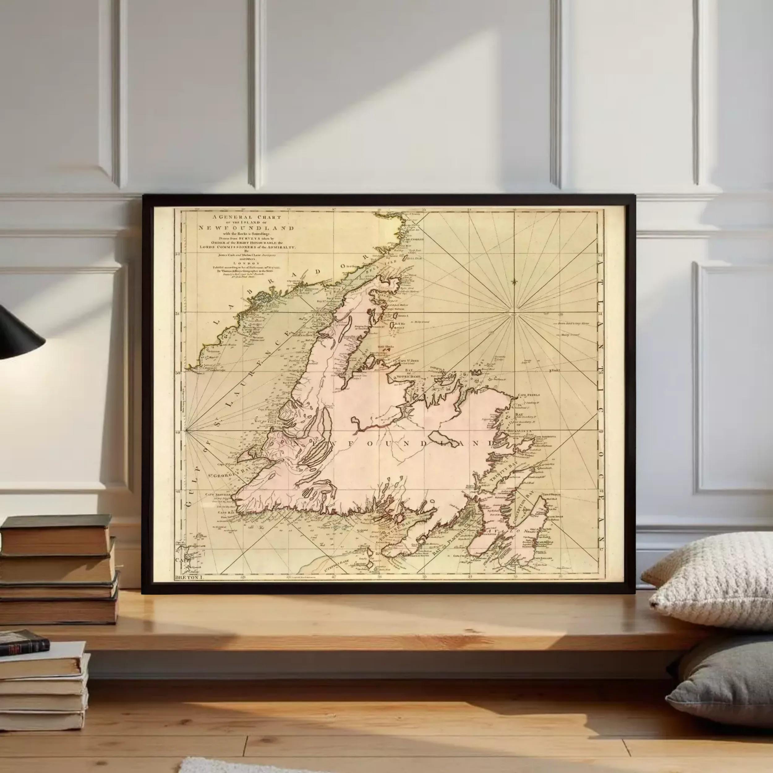 a framed map of New England, a region in the United States, with a wooden shelf and some books in the foreground.