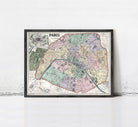 The image is a framed vintage map of Paris, France, depicting the city's streets and neighborhoods in a detailed and colorful manner.