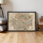 The image is a framed vintage map of a city, likely from the 19th century, displayed on a white wall.