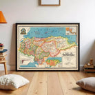a framed map of Honduras, with a wooden floor and a few books and pillows in the background.
