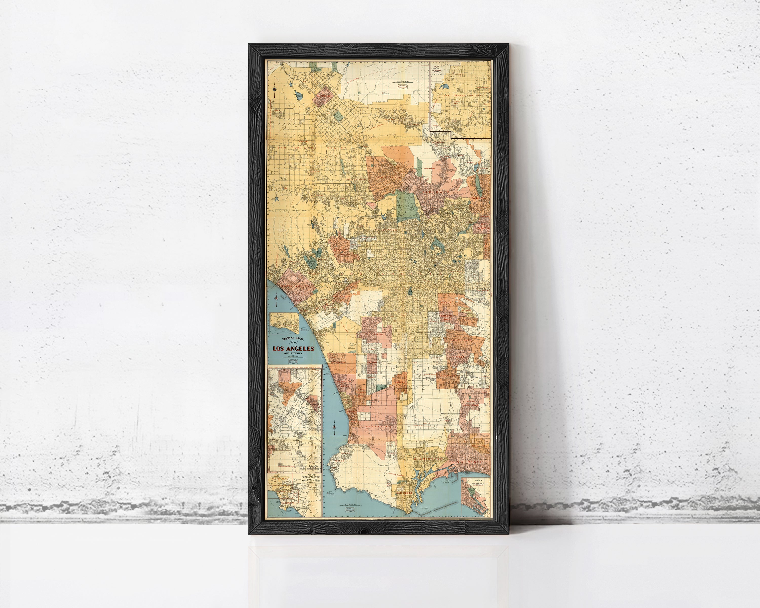 The image is a framed vintage map of Los Angeles, California, with a black border and a colorful, detailed depiction of the city's streets and neighborhoods.