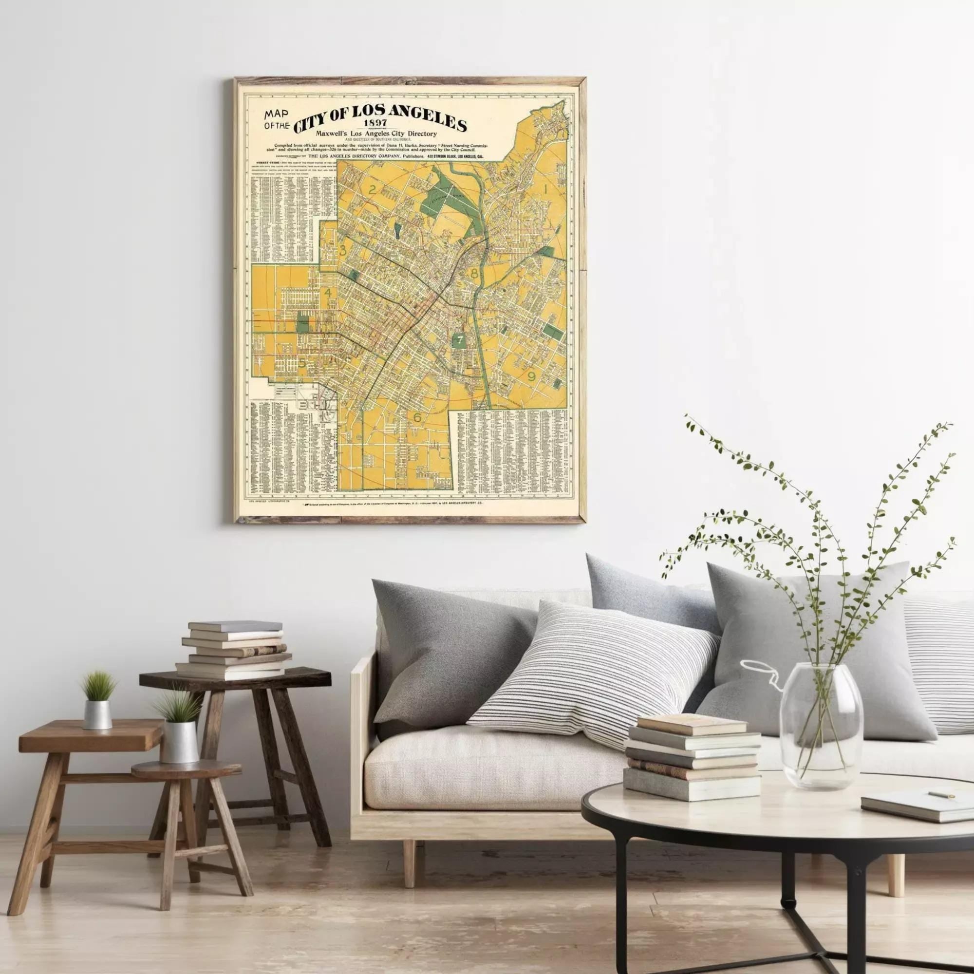 a framed vintage map of Los Angeles, with a cozy living room setting in the background.