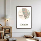 a framed map of New York City hanging on a wall in a living room.