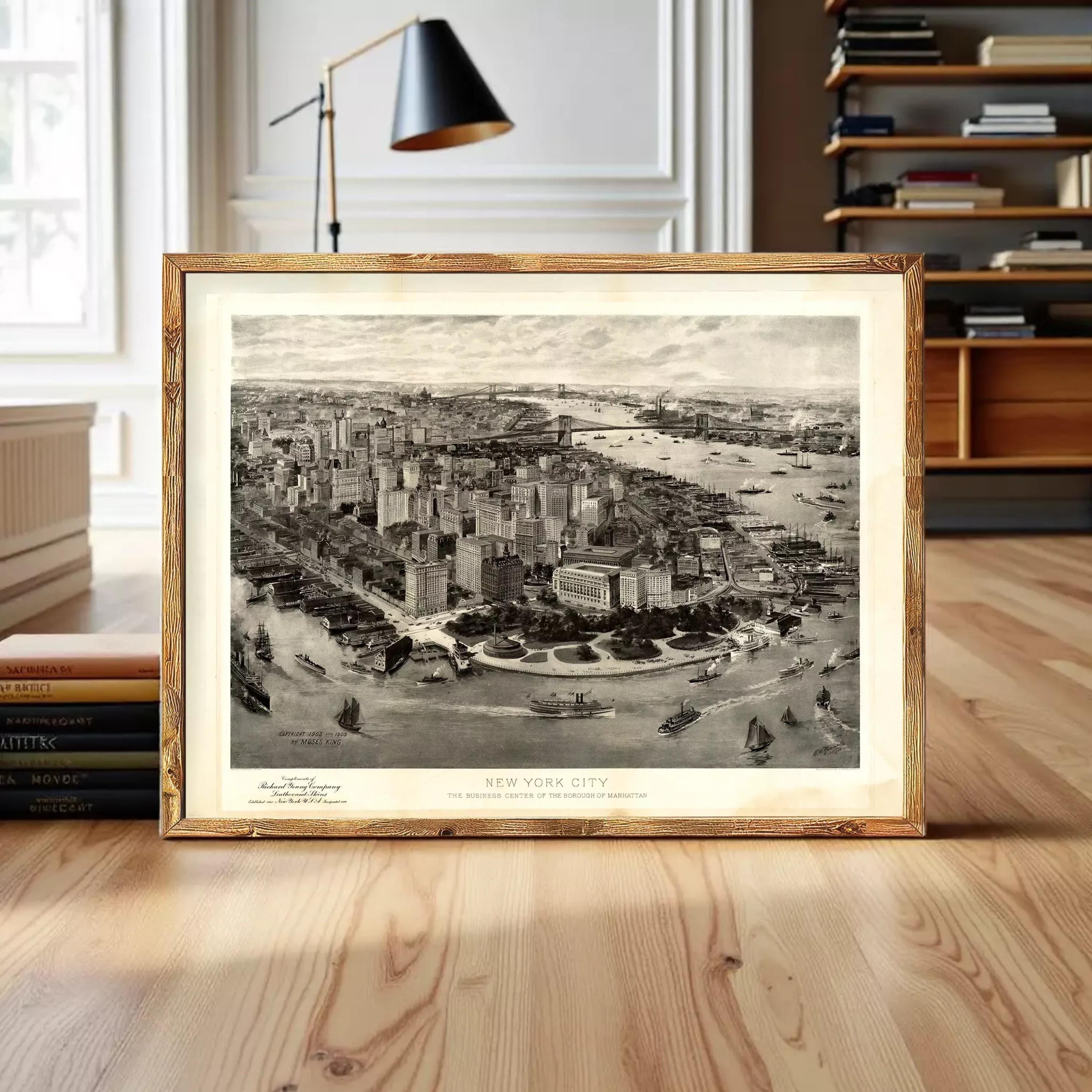 A framed black and white illustration of New York City, depicting the cityscape with boats and buildings, is displayed on a wooden surface.