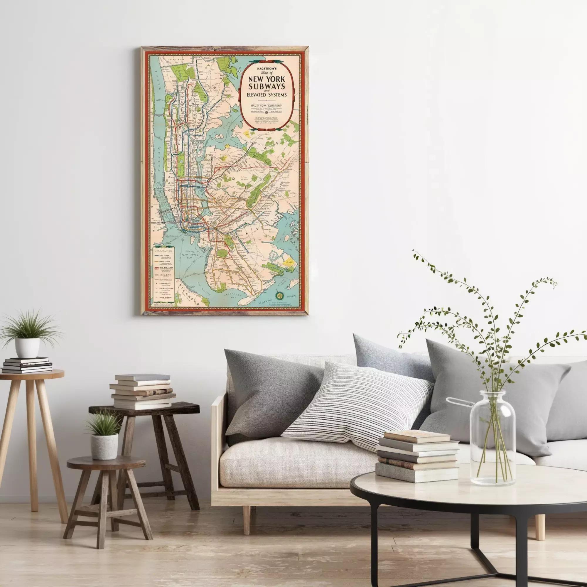 a living room with a large framed subway map hanging on the wall, a gray sofa with a stack of books, a wooden side table, and a vase with greenery.