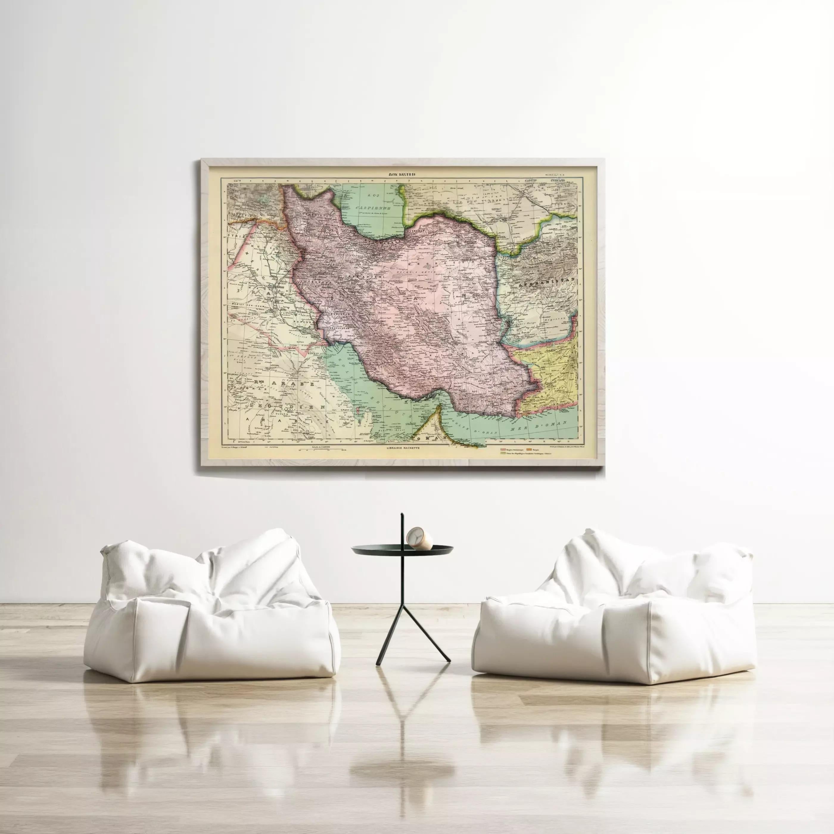a large framed map of Iran hanging on a white wall, with two white bean bag chairs positioned in front of it.