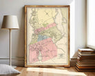 The image is a framed vintage map of a city, likely from the late 19th century, depicting the layout and boundaries of the city.