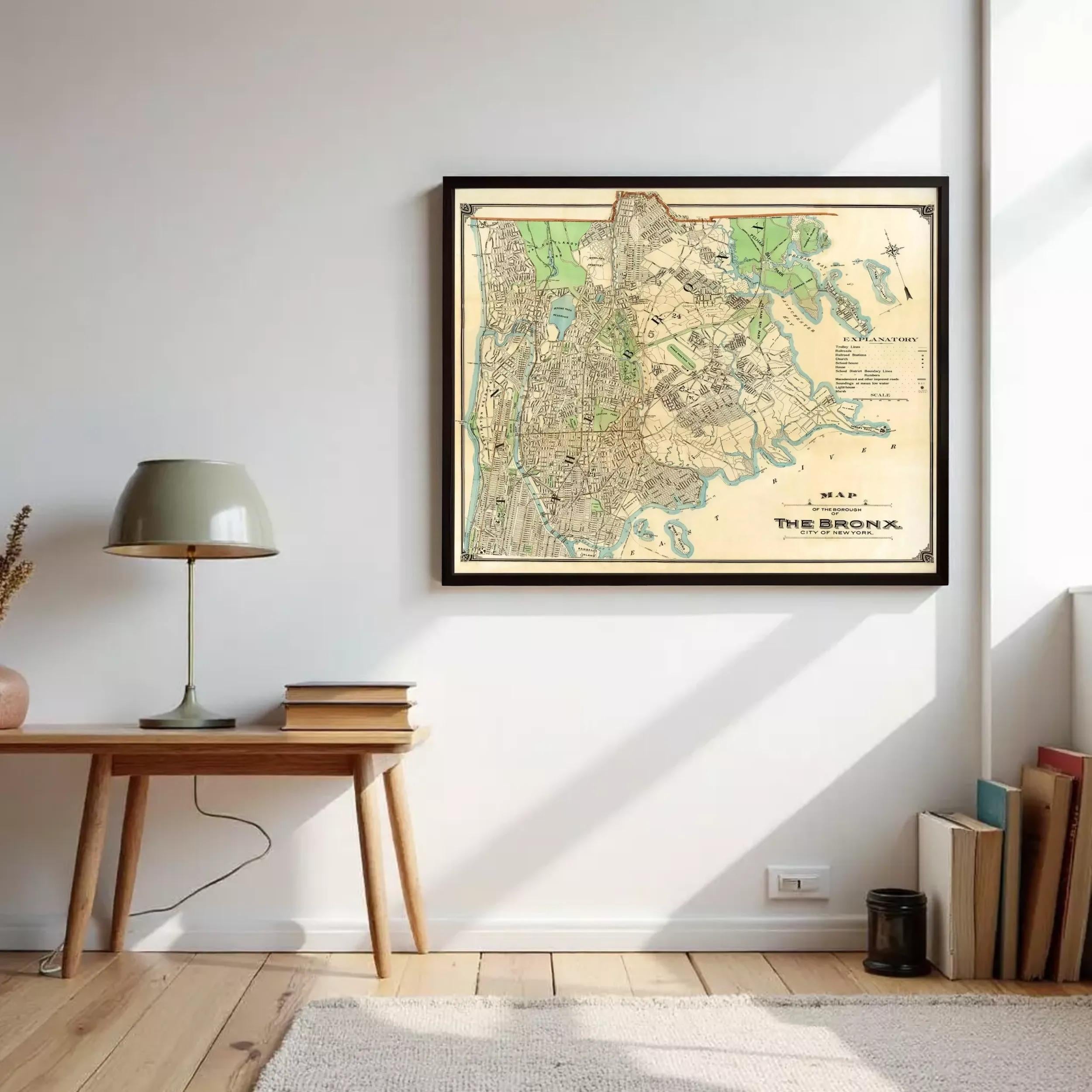 a framed map of the New York City area hanging on a wall, with a wooden table and lamp nearby.