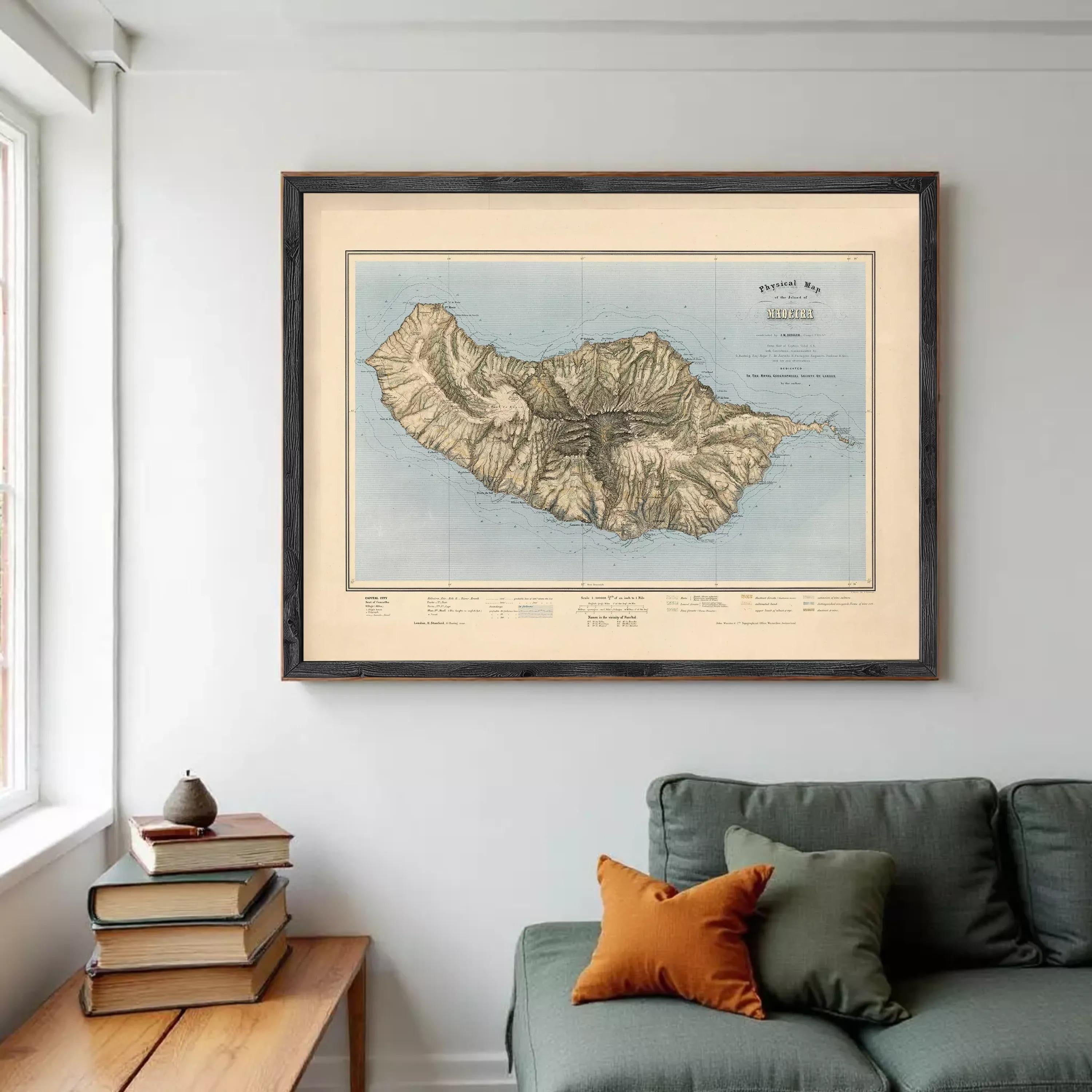 a large framed map of a mountainous region hanging on a wall in a living room.