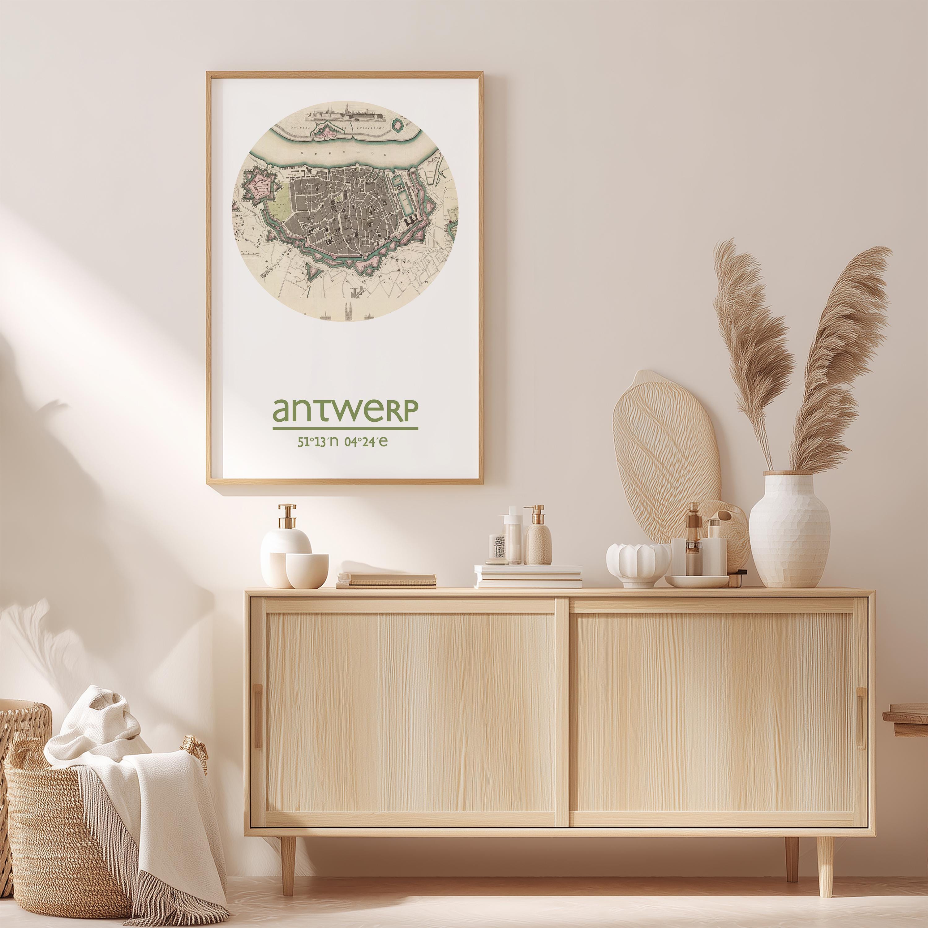 a wooden cabinet with a framed map of Antwerp, a city in Belgium, hanging on the wall above it. The cabinet is situated in a room with a beige color scheme, and there are decorative elements such as a potted plant, a vase, and a book on the cabinet.