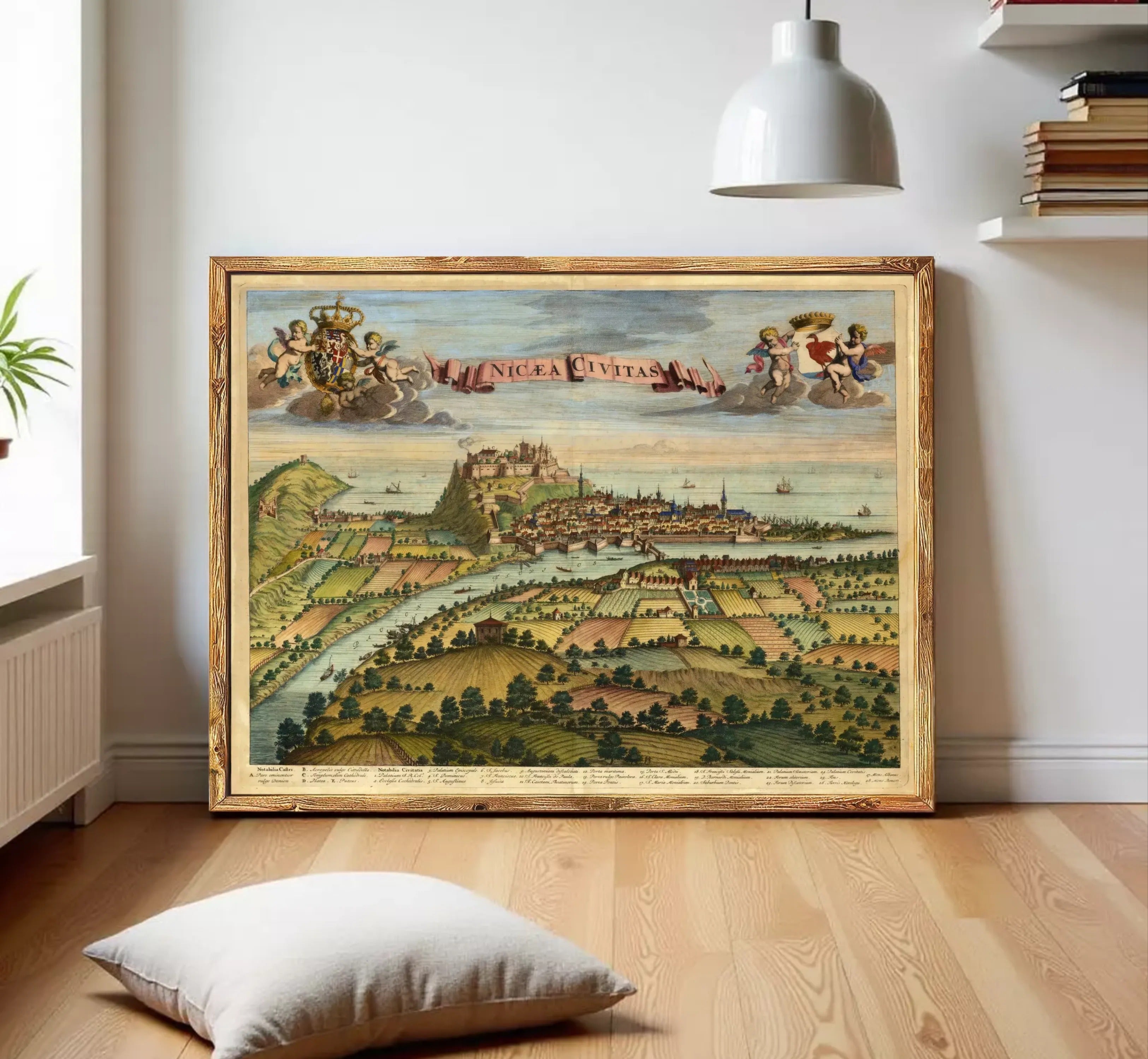 The image is a framed painting depicting a cityscape with a river, mountains, and clouds in the background.