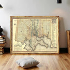 The image is a framed antique map of a city, likely Washington, D.C., with detailed cartography and geographical information.