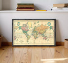 A framed vintage world map is displayed on a wooden floor, with a shelf above it holding books and a pencil.