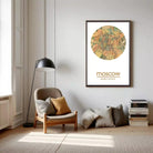 a living room with a large circular map of Moscow hanging on the wall, a wooden chair, a lamp, and a stack of books.