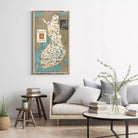 a living room with a large map of Finland hanging on the wall, a wooden coffee table with books and a vase of greenery, and a comfortable couch with pillows.