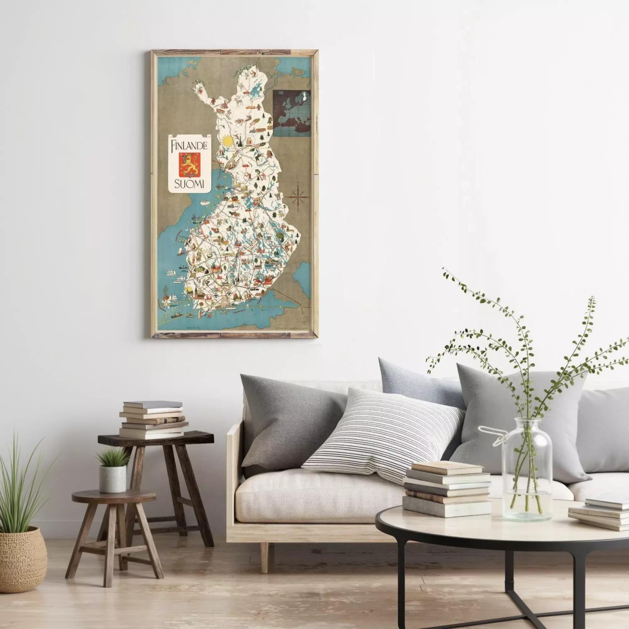 a living room with a large map of Finland hanging on the wall, a wooden coffee table with books and a vase of greenery, and a comfortable couch with pillows.