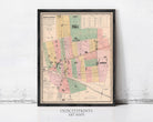 The image is a framed vintage map of a city, likely from the early 20th century, with various colored sections representing different neighborhoods or districts.