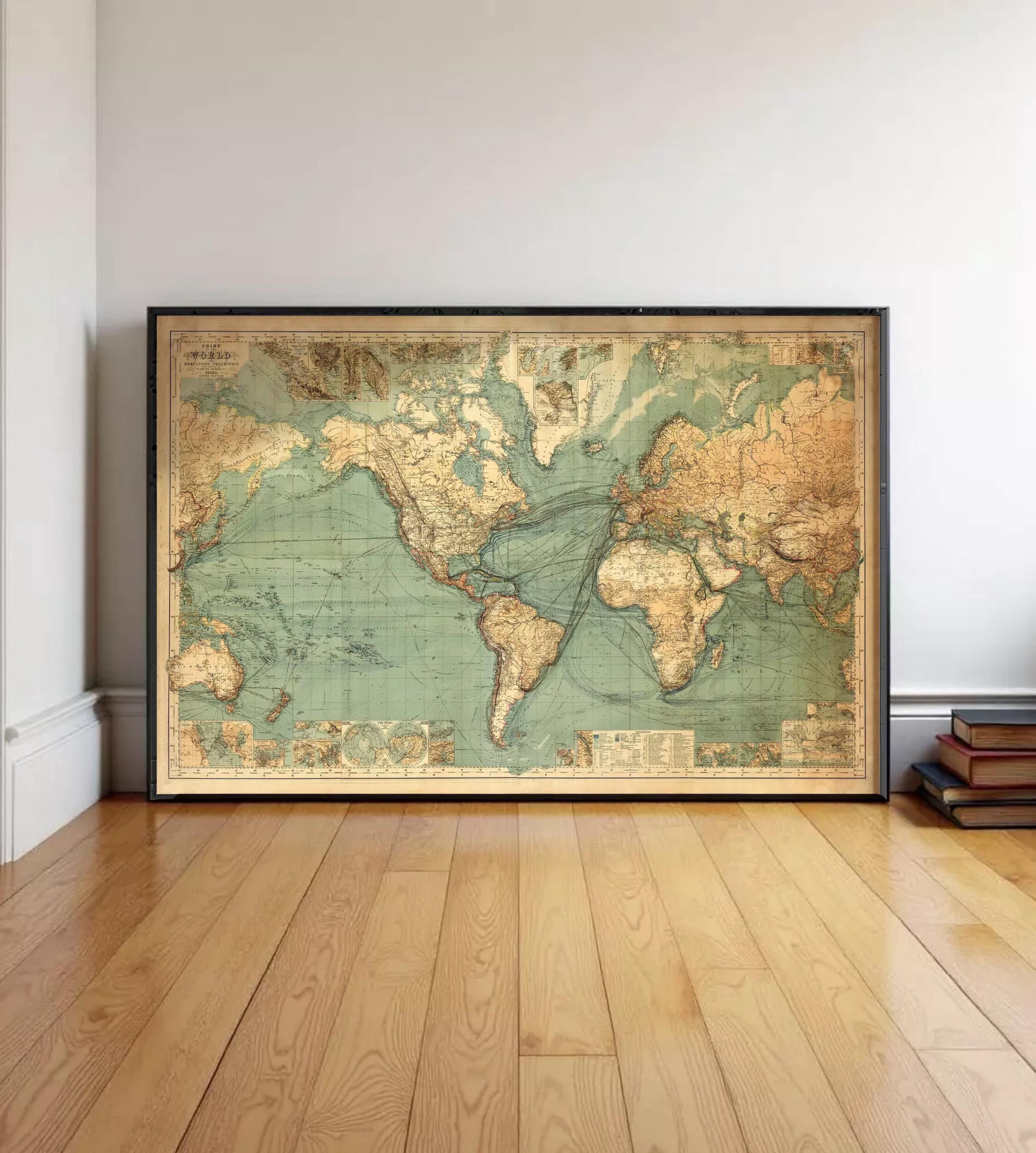 A large, framed vintage map of the world is displayed on a wooden floor in a room.