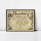 The image is a framed antique map of a city, depicting a detailed layout of the streets and surrounding areas.