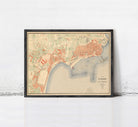The image is a framed vintage map of a city, likely from the early 20th century, depicting the city's layout and surrounding areas.