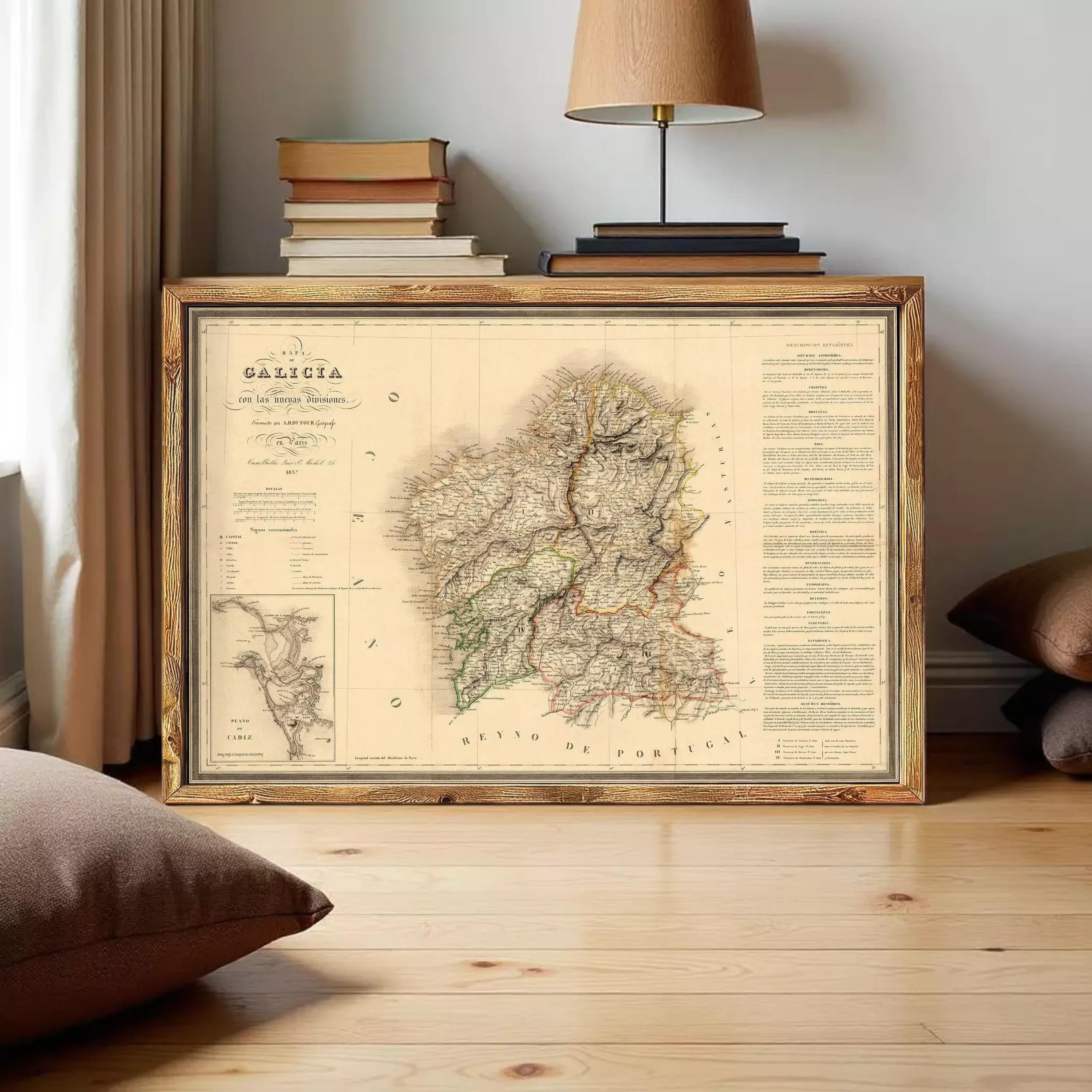 a framed map of Galicia, Spain, with a wooden frame and a lamp on a table in the background.