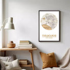 a cozy living room with a wooden table, a lamp, a stack of books, and a framed map of Melbourne, Australia.