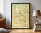 a framed map of the state of Utah, with a lamp and a stack of books in the background.