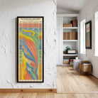 a colorful abstract painting hanging on a white wall in a room with a wooden floor.