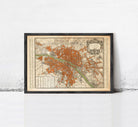 The image is a framed vintage map of a city, likely Paris, with a detailed and intricate design.