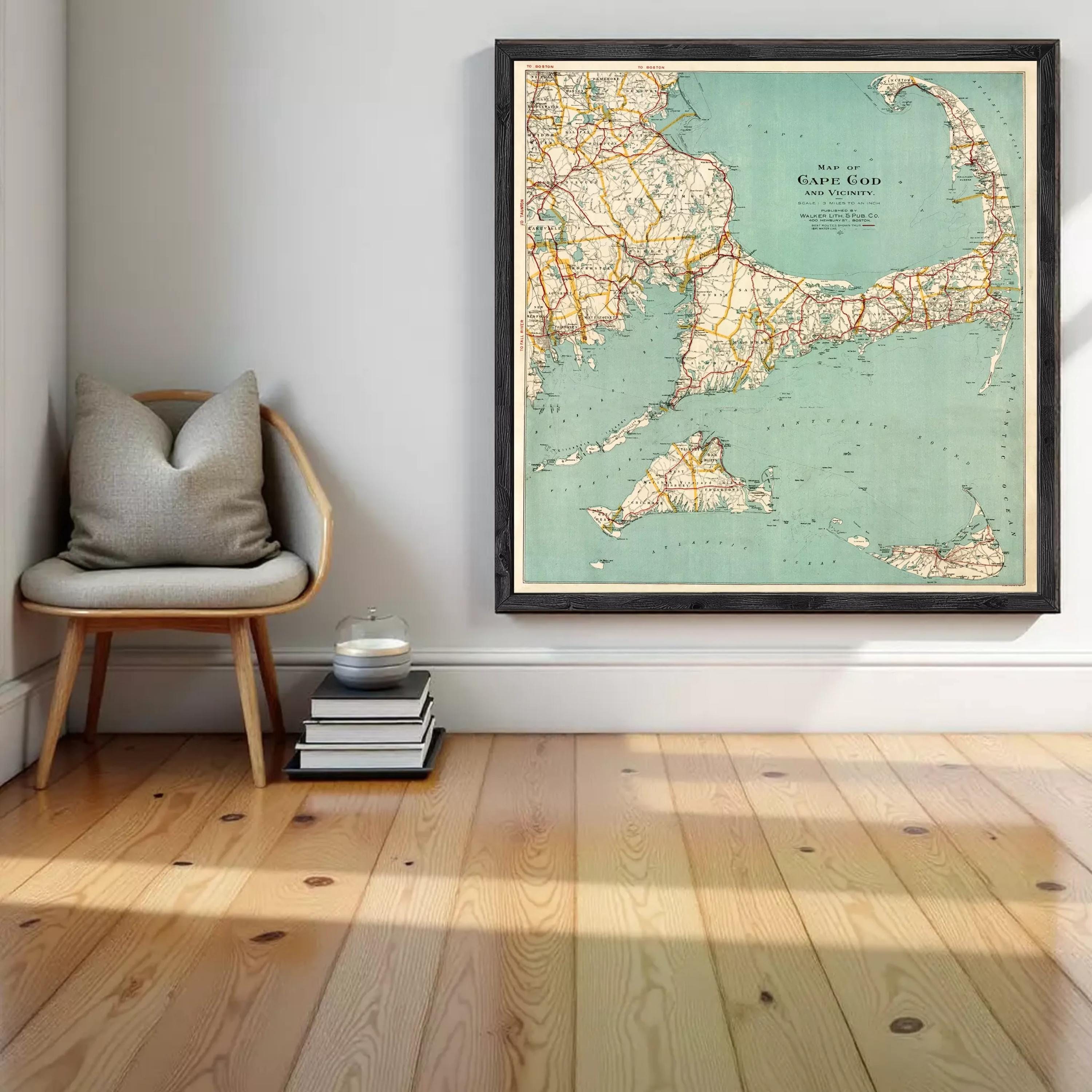 a large framed map of Cape Cod, a coastal region in Massachusetts, Massachusetts, United States. The map is hanging on a wall, and there is a stack of books and a chair in the foreground.