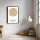 a framed map of Rockford, Illinois, with a lamp and a stack of books on a table next to it.