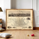 a large framed map of Liverpool, with a detailed illustration of the city's streets and landmarks. The map is displayed on a wooden floor, and there are some books and toys in the foreground.