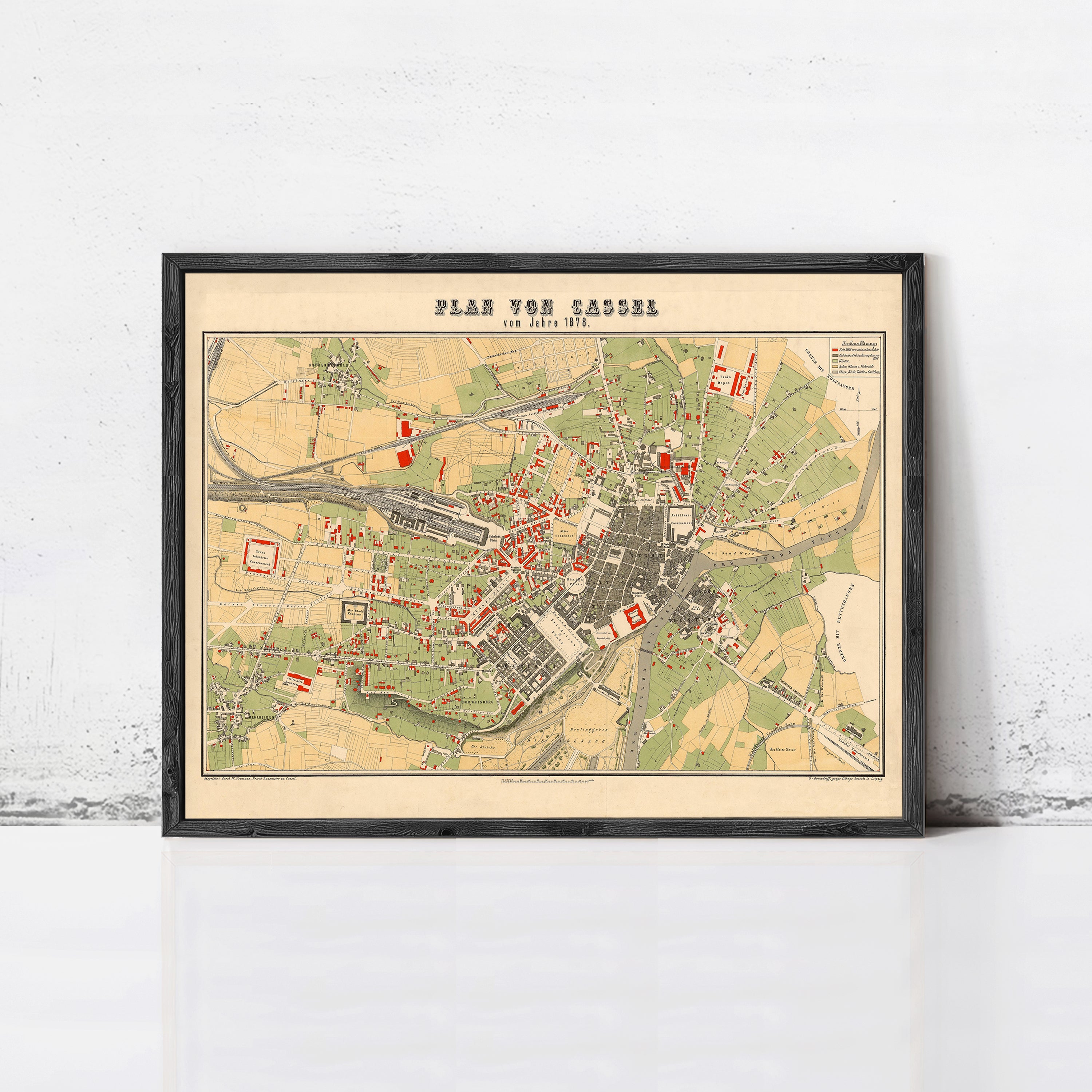 The image is a framed vintage map of a city, depicting various landmarks and streets.