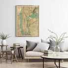 a living room with a large framed map of New York City hanging on the wall above a couch with pillows and a coffee table.